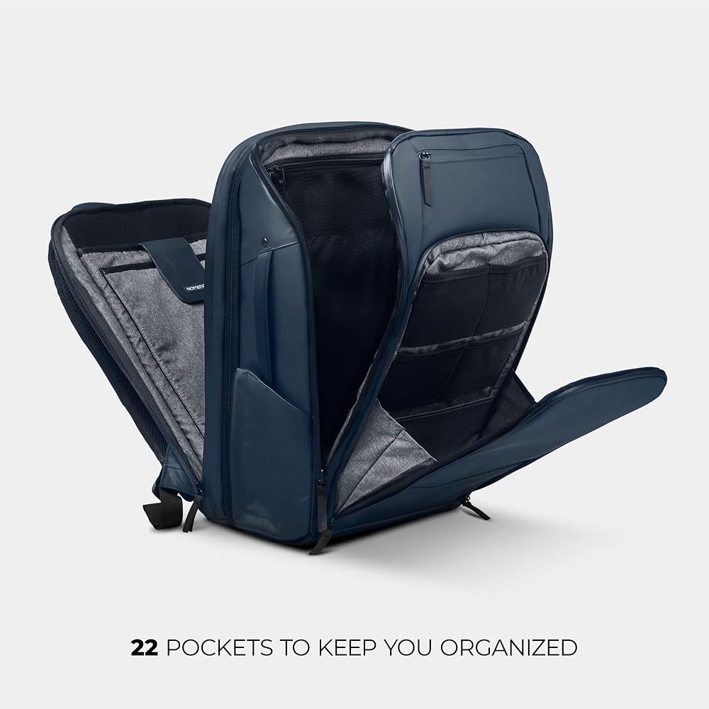 Person wearing NOMATIC Travel Pack 20L while traveling through airport terminal with luggage